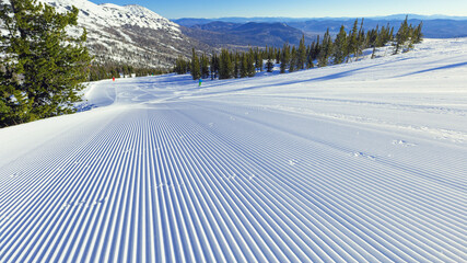Snow velvet and blue sky on ski slope on on mount Green, Sheregesh ski resort. Prepared ski and...