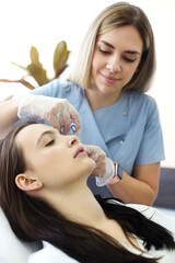 Fototapeta premium Cosmetologist making injection during beauty procedure in salon