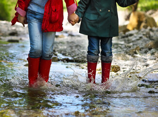 Child wearing rain boots jumping. Close up