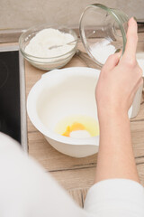 Woman's hands kneading dough in a bowl on the kitchen