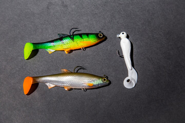 Fishing tackle on a black background. Top view. colorful silicone fish lures with hooks fishing equipment © Yelena