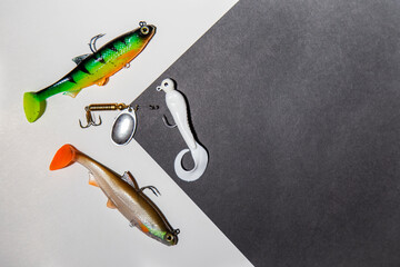 Fishing tackle on a black and white abstract background. Top view. colorful silicone fish lures with hooks fishing equipment © Yelena