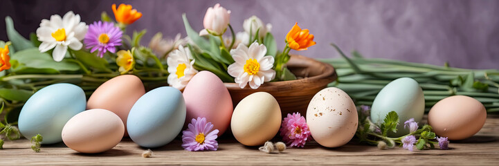 Fototapeta na wymiar Multicolored Easter eggs on the table with spring flowers - Easter banner with a space for text