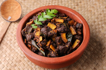 Spicy red beef fry curry and brown rice South Indian dish Kerala, India. side of Ghee rice, Appam, Parotta, Puttu. traditional Christian Muslim feast dish. Buffalo roast, meat pepper fry with coconut.