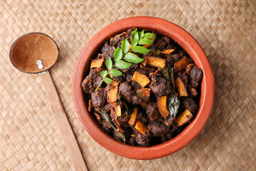 Spicy red beef fry curry and brown rice South Indian dish Kerala, India. side of Ghee rice, Appam, Parotta, Puttu. traditional Christian Muslim feast dish. Buffalo roast, meat pepper fry with coconut.