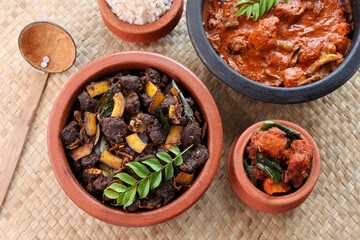 Spicy red beef fry curry and brown rice South Indian dish Kerala, India. side of Ghee rice, Appam, Parotta, Puttu. traditional Christian Muslim feast dish. Buffalo roast, meat pepper fry with coconut.