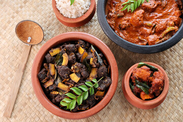 Spicy red beef fry curry and brown rice South Indian dish Kerala, India. side of Ghee rice, Appam, Parotta, Puttu. traditional Christian Muslim feast dish. Buffalo roast, meat pepper fry with coconut.