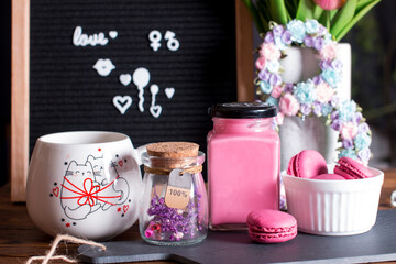 Congratulations on International Women's Day on March 8. Greeting card with a cup of hot drink with flowers and sweet pink cakes