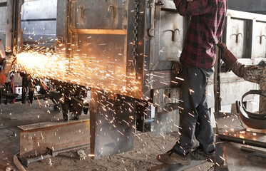 Working with Power Tools - Stock photo of Man Using Angle Grinder with Sparks Flying, Man using...