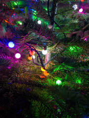 Close up of a Christmas tree with colourful balls of light