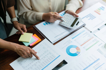 Business colleague using calculator to checking budget and discussing about financial of business