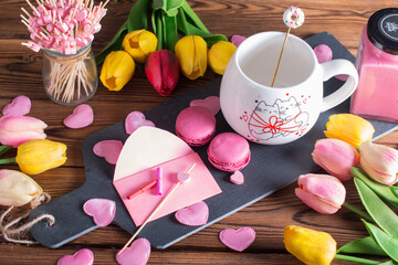 valentine's day. Greeting card with a cup of hot drink with flowers and sweet pink cakes