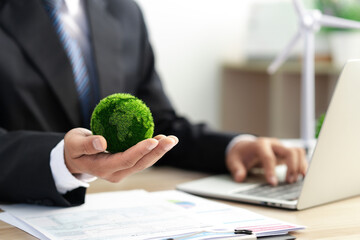 Businessman holds a green ball globe. ESG concept. Environmental, social and governance...