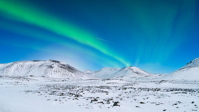 Aurora Borealis. Northern Lights over the mountains. Scandinavia. Winter night landscape with bright lights in the sky. Landscape in the north in winter time.