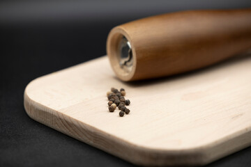Pepper mill on wooden board