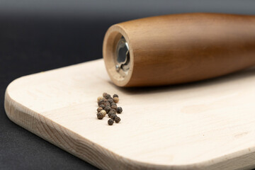 Pepper mill on wooden board