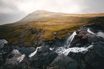 landscape in the morning with meadows, mountains and waterfalls