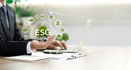 Businessman holding a green tree with esg icon. Concept of esg, environmental, social and...