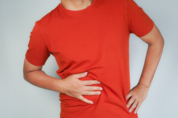 male having stomach ache, bending over and holding hands on stomach, uncomfortable due to stomach...