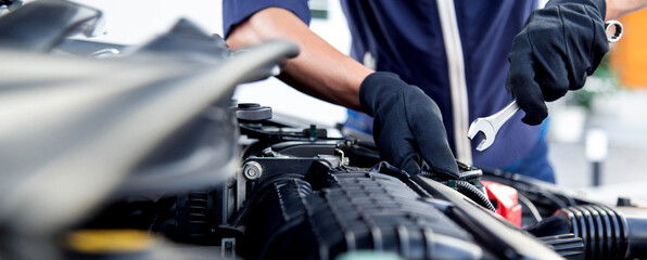 Professional mechanic working on the engine , repairing a car engine automotive workshop with a wrench, car service and maintenance,Repair service.