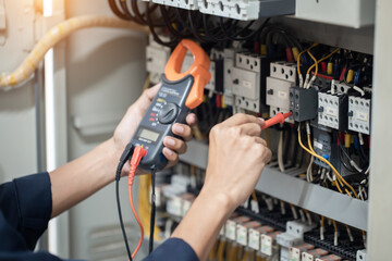 Electrician engineer work tester measuring voltage and current of power electric line in electical...
