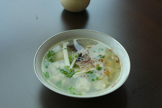 A bowl of Tekwan on white background. Tekwan is traditional soup with fish ball, jicama, rice noodle and mushroom.