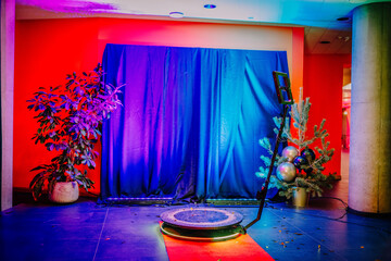  indoor photography setup with a 360-degree spinner, colorful lighting, a stage curtain backdrop,...