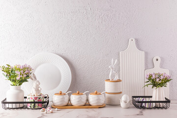 Stylish kitchen background for Easter holiday with traditional symbols and white tableware....