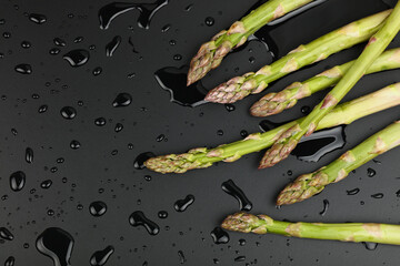 Fresh green washed asparagus on black - Powered by Adobe