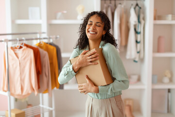 Happy businesswoman hugging a package in her office