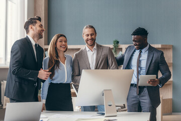 Group of business people looking happy while having quick meeting in the office together
