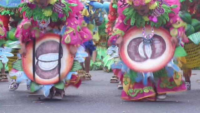 During the annual celebration of the coconut festival, street dancers in various local and native costumes perform in a frenzy along the street to pay homage to a Patron Saint.