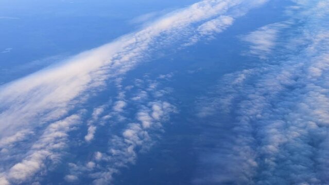 Restless beautiful clouds on the blue sky above the ground. Aerial Photography