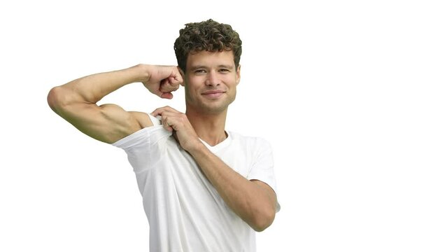 A man in a white T-shirt, on a white background, close-up, shows strength