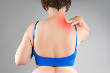 Neck pain, woman suffering from backache, gray background, health problems concept