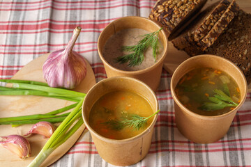 Pea soup,vegetable and Mushroom cream soup in paper disposable cups for take-out or delivery of food.