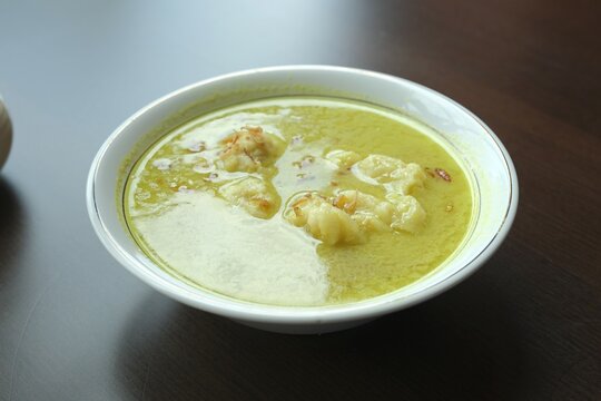 A bowl of Celimpungan, traditonal food from Palembang. This food like Laksan but with large sized tekwan balls with  coconut milk gravy, the thick sauce is simmered with turmeric, pepper, bay leaves.
