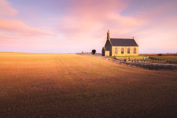 The lone chapel Boarhills Church during a colourful sunset or sunrise in the rural countryside...