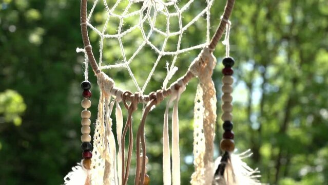 Dream catcher and green trees on the background.
