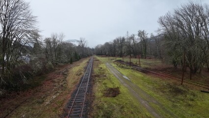 view from the top of an abandoned railroad track as it runs through a green field