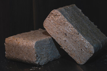 Close-up of a wood briquettes, pressed sawdust on a dark background. Solid fuel from wood chips and...