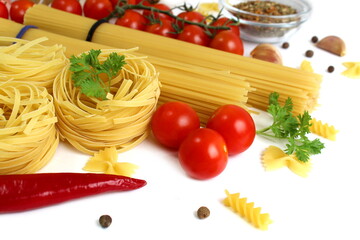 Spaghetti pasta and nests with vegetables lie on a white background.	