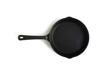 A black cast iron frying pan lies on a white background.