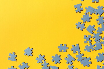 Blue small scattered puzzles lie on a yellow background.