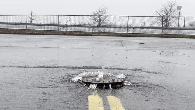 School Bus Passing In Distance By Overflowing Manhole