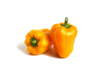 Two yellow peppers lie on a white background.