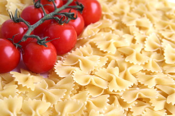 Background of pasta and cherry tomatoes on a branch.	