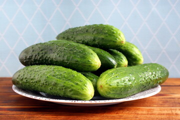 There are a lot of fresh green cucumbers on the plate.