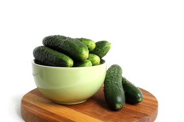There is a plate with fresh cucumbers on a white background.