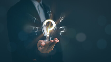Man holding a light bulb with a question mark, concept of problem analysis Creative analytical...